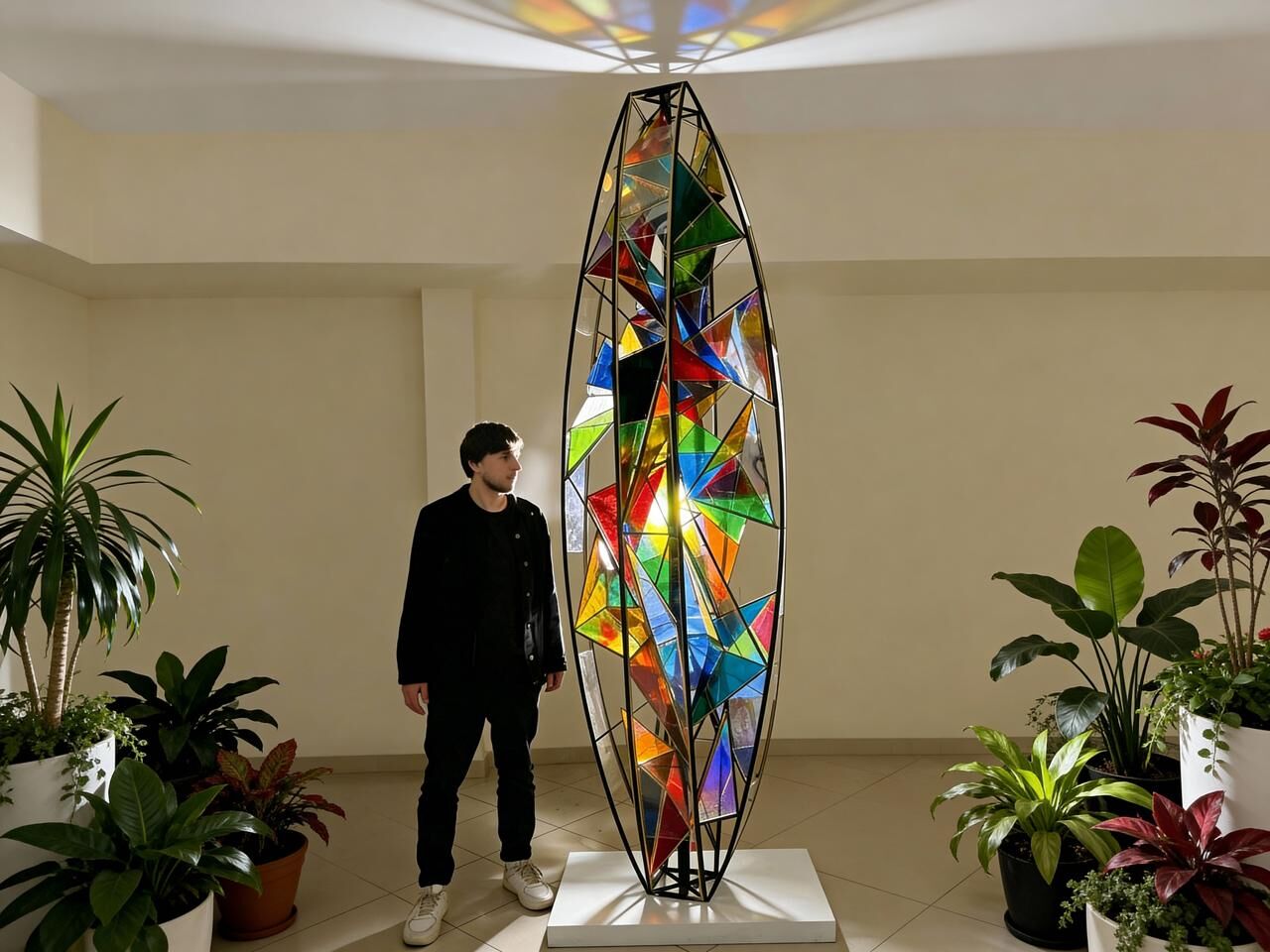 Arthemii standing next to a tall multicoloured glass sculpture