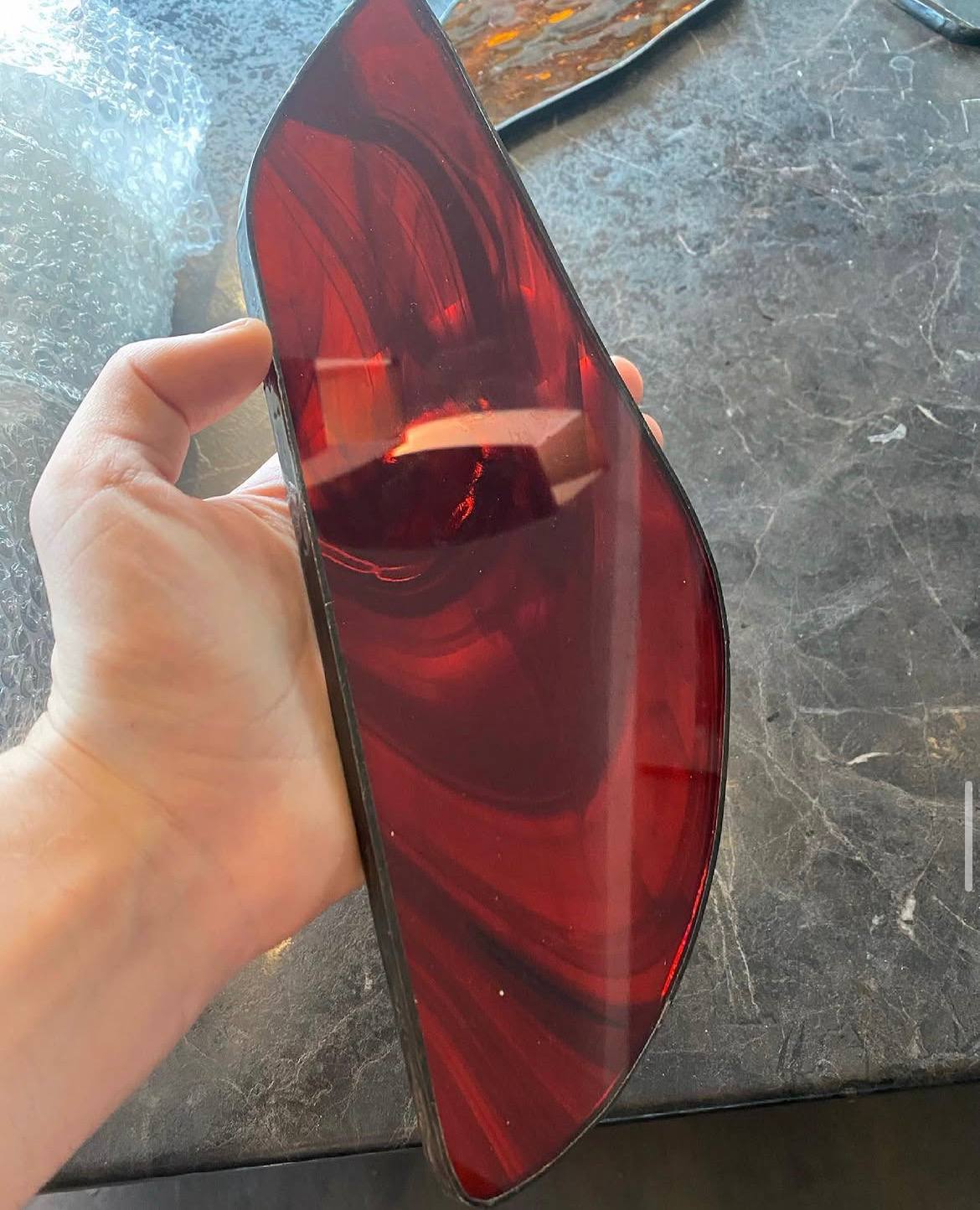 Hand holding red glass piece